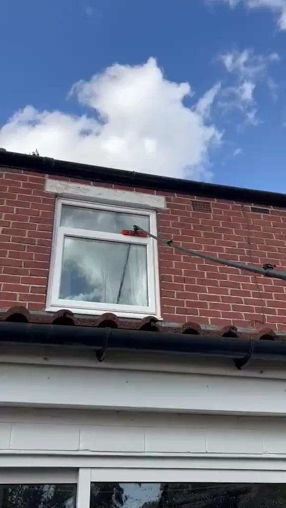 A water-fed pole cleaning a first-floor window
